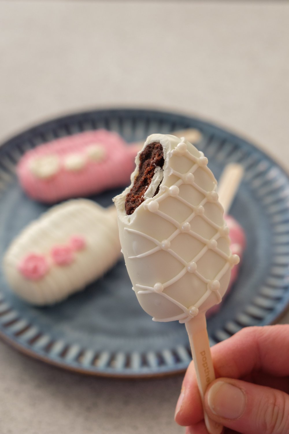 White cakesicle with a bite revealing its chocolate cake centre